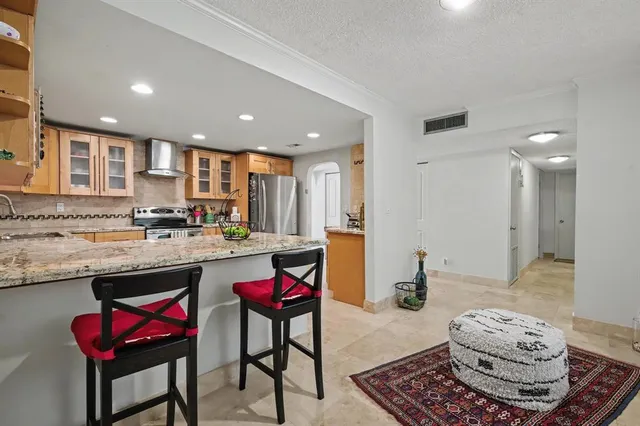 a kitchen with granite countertop a stove a sink dishwasher and white cabinets with wooden floor