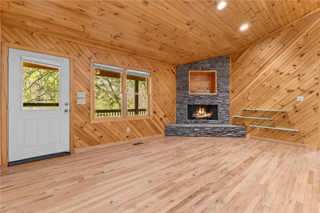 148 Woodby Ridge Road Vilas, NC 28692 - Photo 12 of 33 a view of an empty room with wooden floor fireplace and a window