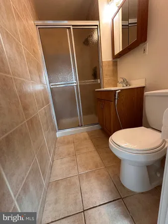 a white toilet sitting next to a shower