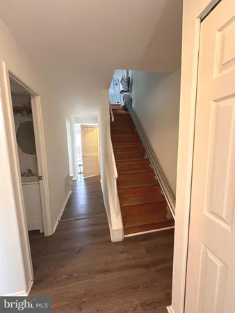 a view of a hallway with wooden floor and stairs