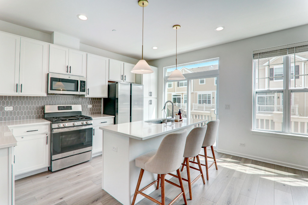 204 Timberleaf Circle Roselle, IL 60172 - Photo 7 of 22 a kitchen with stainless steel appliances granite countertop a stove a refrigerator a kitchen island a table and chairs