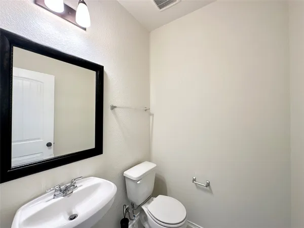 a bathroom with a sink vanity mirror and toilet