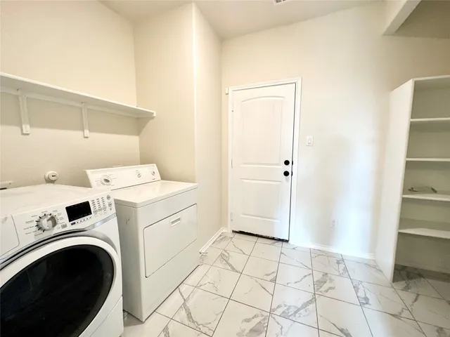 a view of washer and dryer with kitchen in the background
