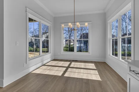 a view of a hallway with wooden floor and stairs