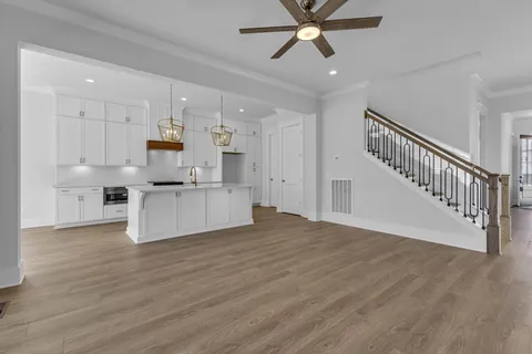 a open kitchen with stainless steel appliances granite countertop a stove top oven a refrigerator a sink and dishwasher with wooden floor