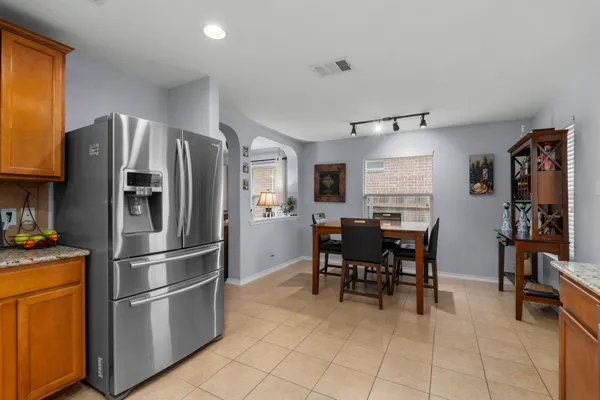 a kitchen with stainless steel appliances granite countertop a refrigerator stove top oven and sink