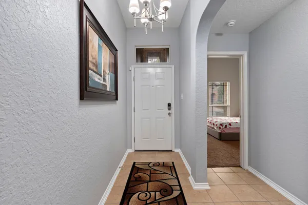 a hallway with windows and chandelier