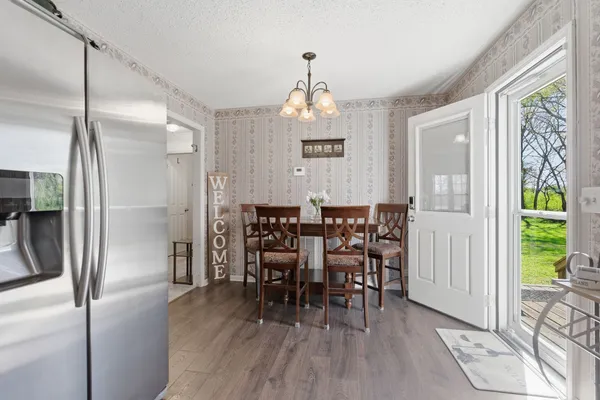 a view of a a dining room with furniture window and wooden floor