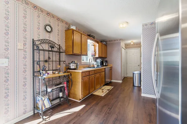 a kitchen with window wooden floor and stainless steel appliances