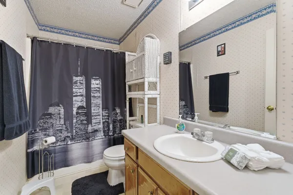 a bathroom with a granite countertop sink toilet and shower