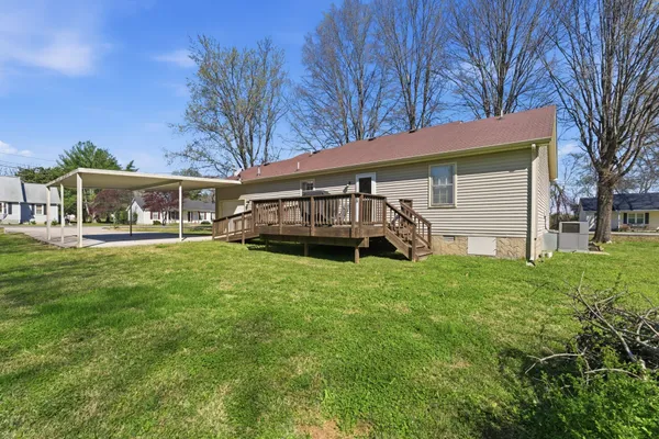 a view of a house with backyard and a tree