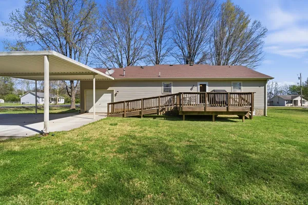 a view of a house with backyard and a tree
