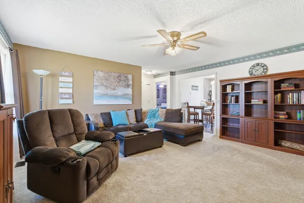 a living room with furniture and view of kitchen