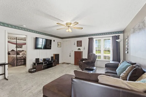a living room with furniture ceiling fan and a window