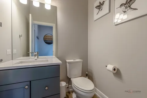 a bathroom with a toilet sink vanity and mirror