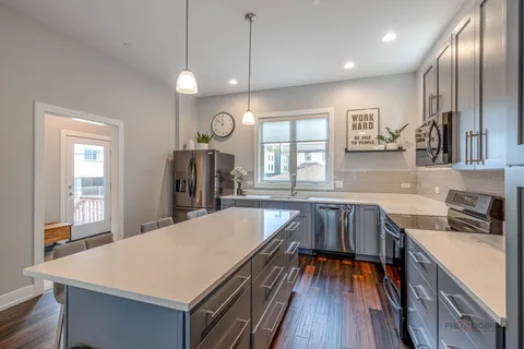 a kitchen with granite countertop a sink a counter space stainless steel appliances and cabinets