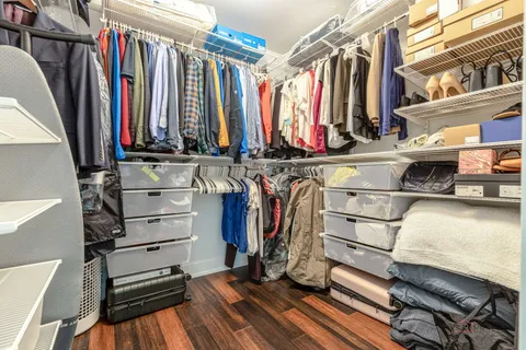 a view of walk in closet with clothes and shoes