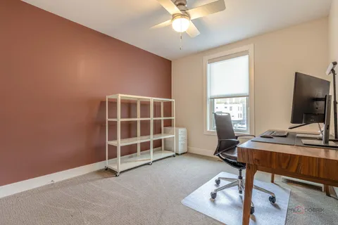 a view of a workspace with furniture and a window