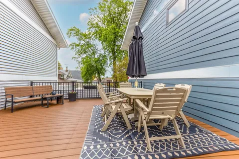 a view of a roof deck with table and chairs and wooden floor