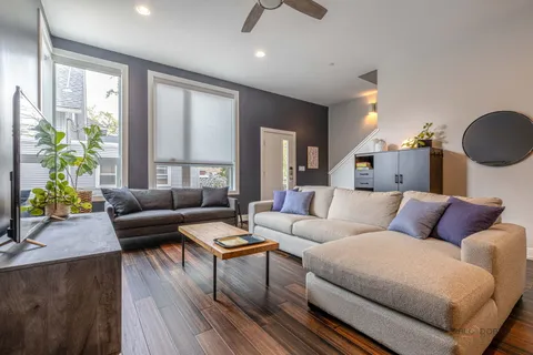 a living room with furniture and a wooden floor