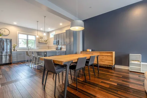 a dining room with a table chairs and a kitchen view