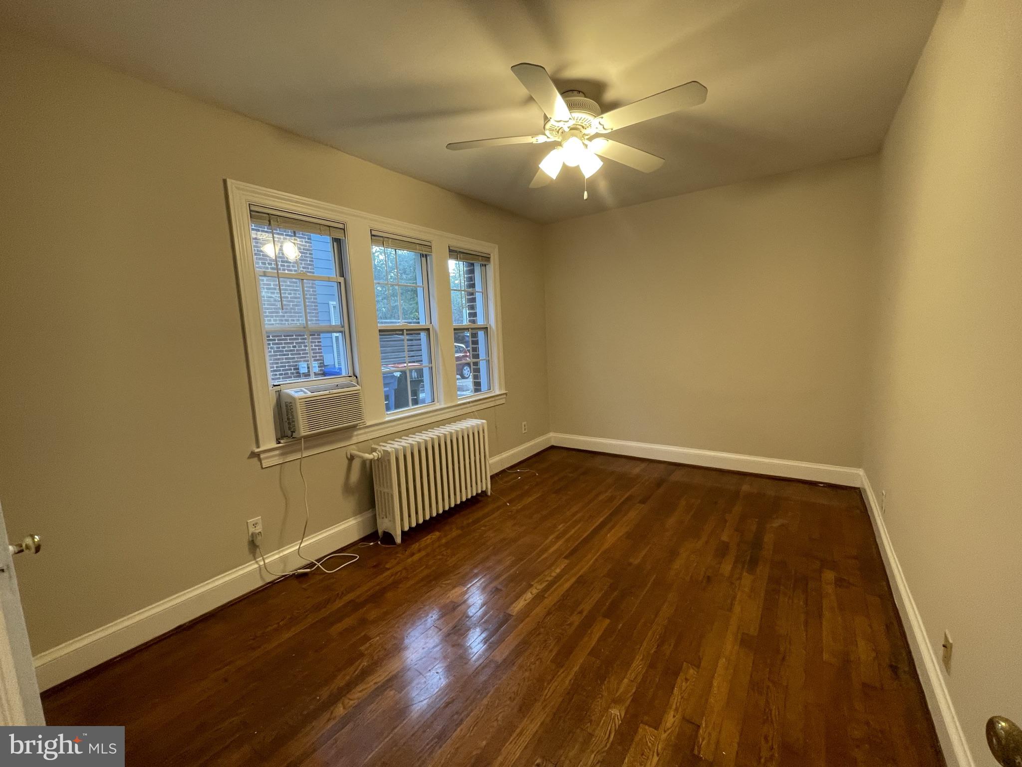 2229 40th Place Northwest, Unit 1 Washington, DC 20007 - Photo 4 of 16 a view of an empty room with wooden floor and a window