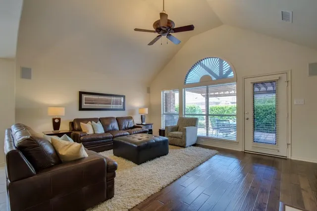a living room with furniture large window and a chandelier