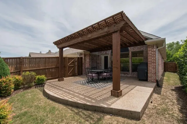 a view of a patio with table and chairs with wooden fence