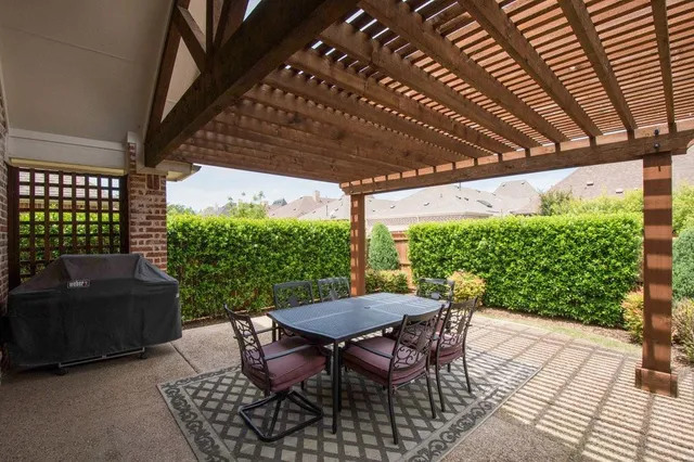 a view of patio with table and chairs potted plants with floor to ceiling window