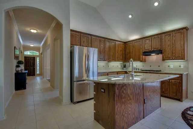 a kitchen with stainless steel appliances granite countertop a refrigerator a stove a sink and a refrigerator