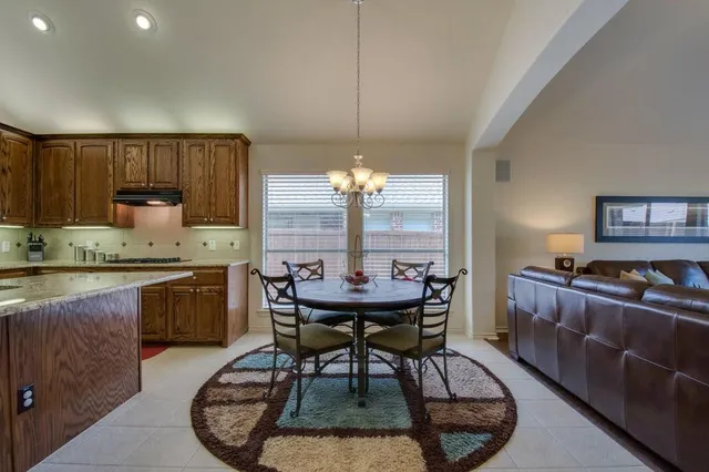 a kitchen with kitchen island a dining table and chairs