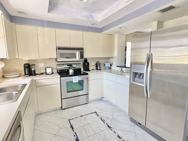 a kitchen with stainless steel appliances granite countertop a sink counter space cabinets and a large window