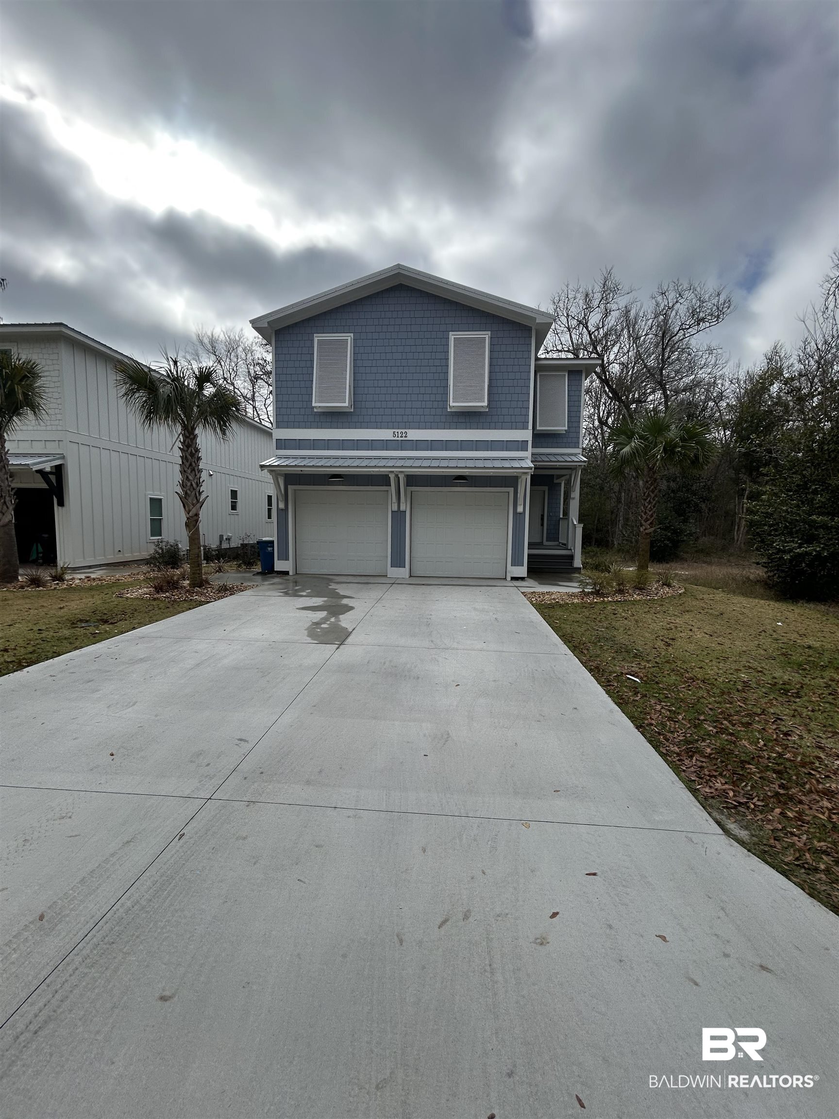 5122 Pine Road Orange Beach, AL 36561 - Photo 2 of 24 Traditional-style house featuring an attached garage, concrete driveway, and a front lawn