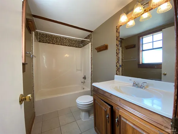 a bathroom with a sink a toilet a mirror and shower