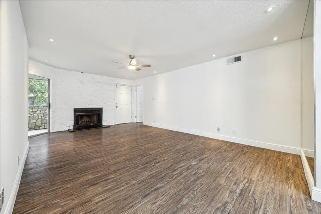 an empty room with wooden floor and fireplace
