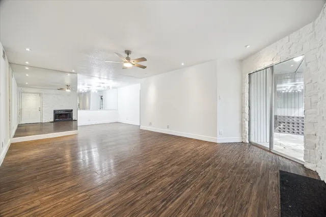 a view of an empty room and a kitchen