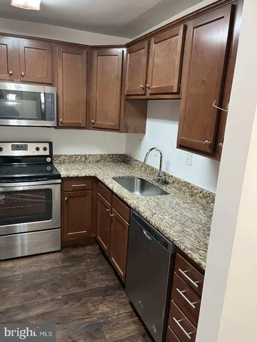 a kitchen with granite countertop a sink and stainless steel appliances