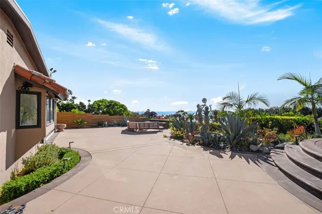 a front view of a house with a yard and potted plants