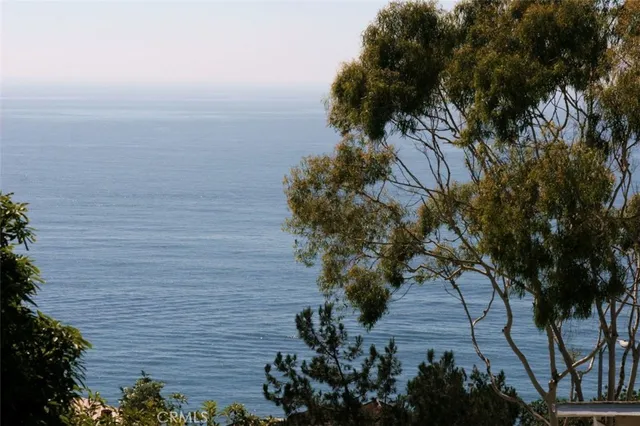 a view of a white house with a yard and sitting area