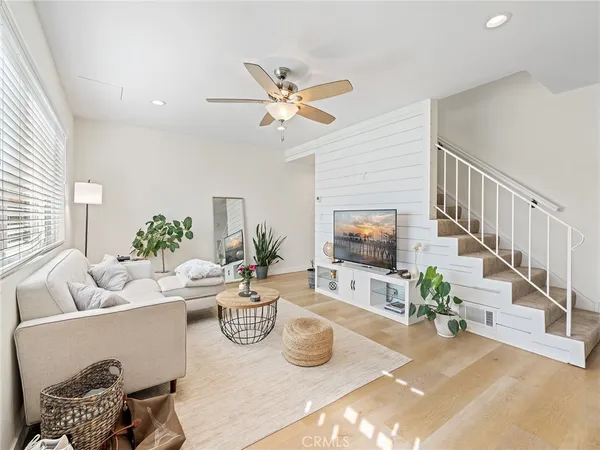 a living room with furniture and a flat screen tv with potted plants