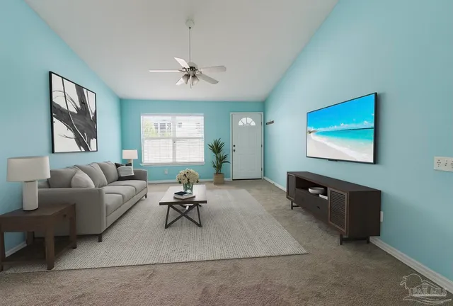 a living room with furniture a window and a flat screen tv
