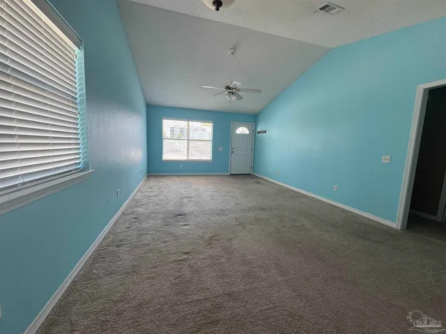 an empty room with a ceiling fan and window