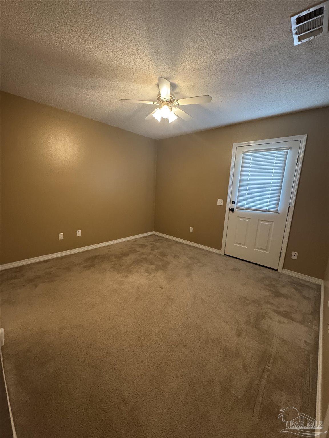 13944 River Road, Unit D Pensacola, FL 32507 - Photo 8 of 14 an empty room with a ceiling fan and window