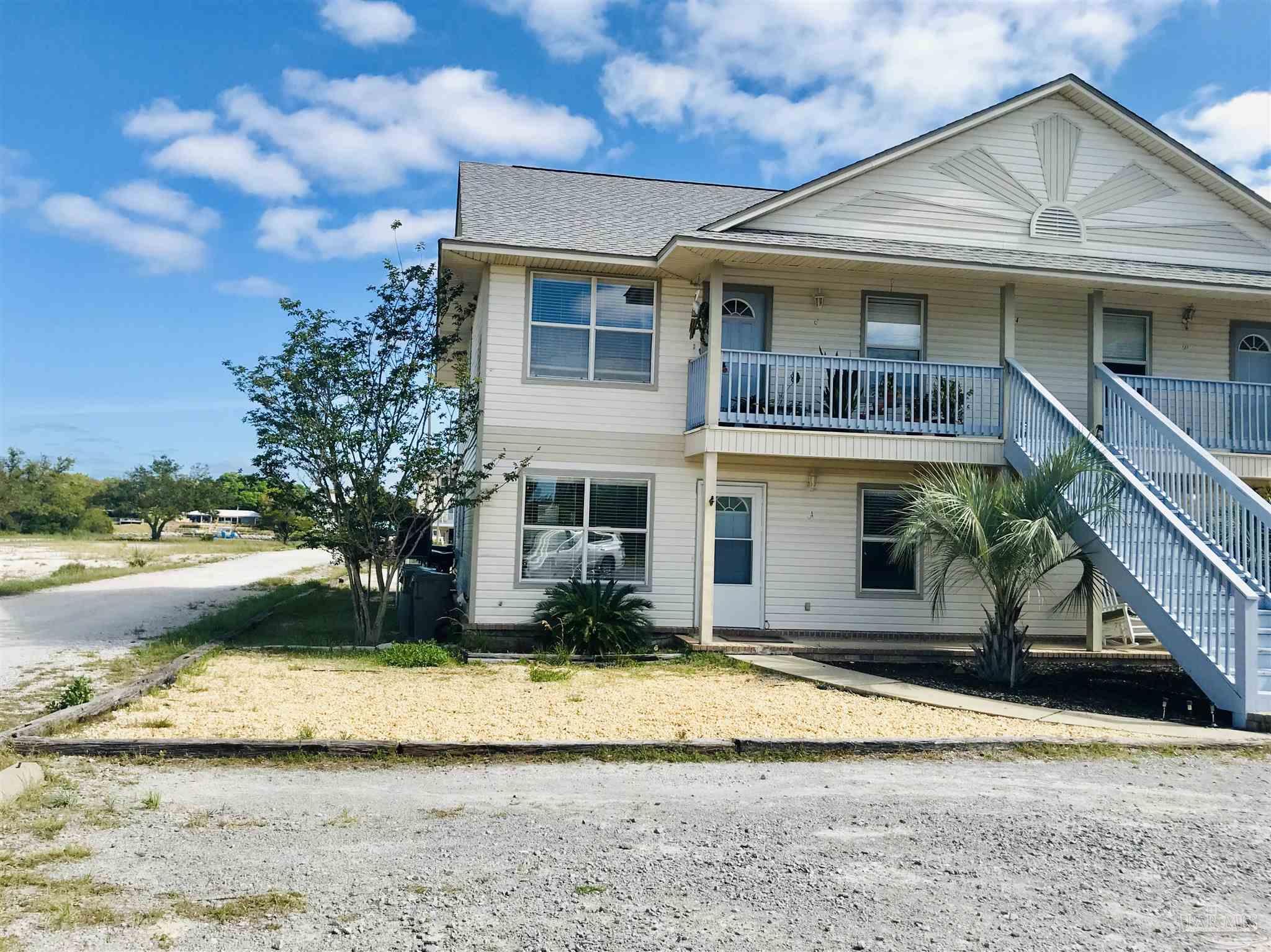 13944 River Road, Unit D Pensacola, FL 32507 - Photo 10 of 14 a view of a white house with a yard and large tree