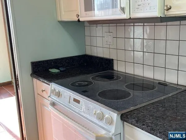 a stove top oven sitting inside of a kitchen