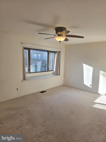 a view of a big room with windows and chandelier fan