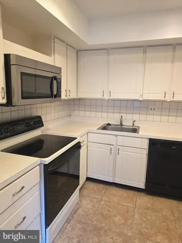 a kitchen with a sink stove and microwave