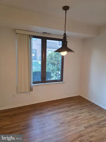 a view of a room with wooden floor chandelier and windows