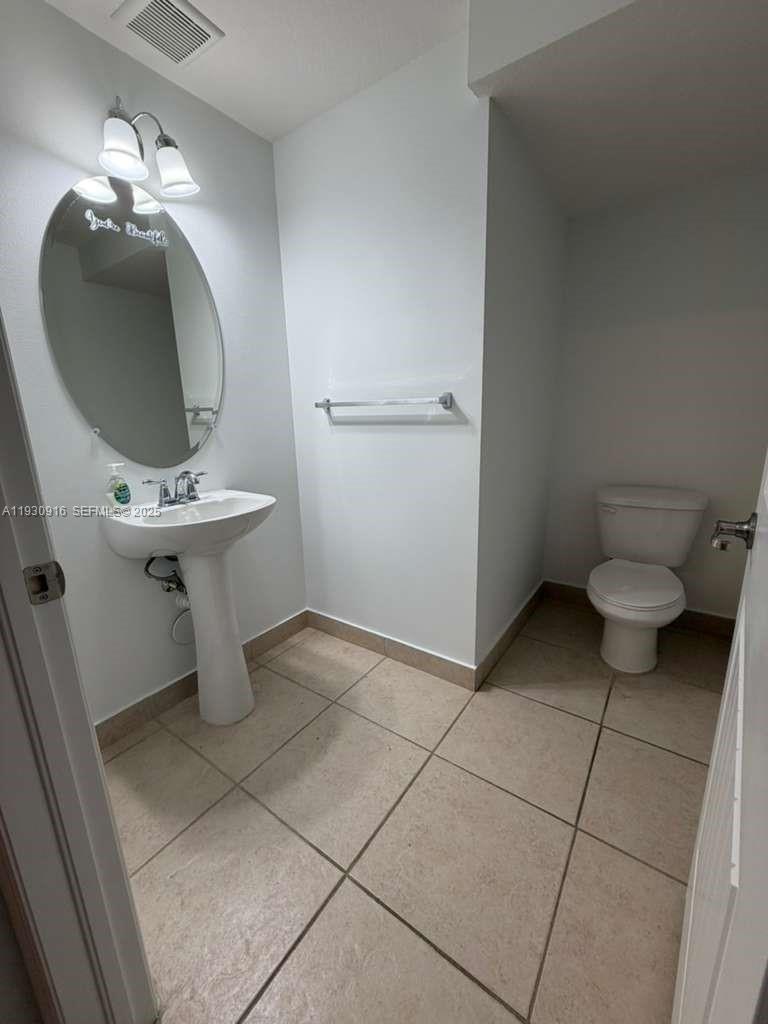 13982 Southwest 276th Street Homestead, FL 33032 - Photo 14 of 15 a bathroom with a toilet and a mirror