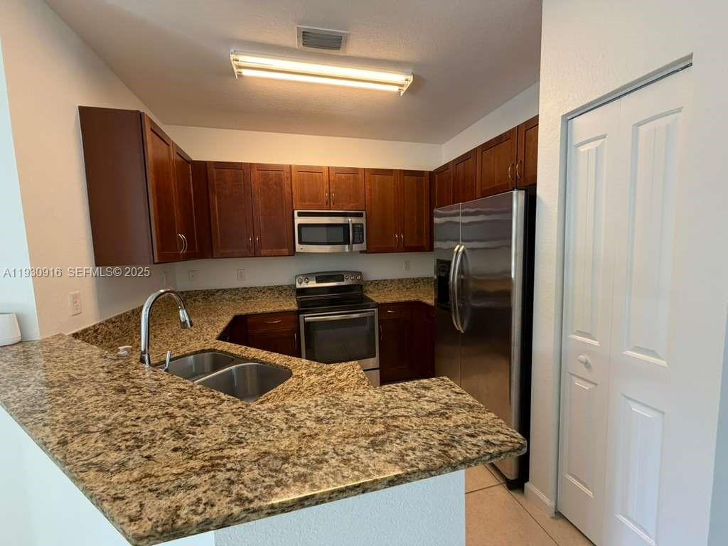 13982 Southwest 276th Street Homestead, FL 33032 - Photo 2 of 15 a kitchen with stainless steel appliances granite countertop a sink refrigerator and microwave